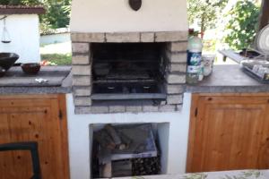a kitchen with a fire place in a counter at Lomtsi Popovo Targovhiste Bulgarije in Lomtsi