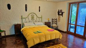 a bedroom with a large bed with a yellow blanket at La Casa di Francesco in Perugia