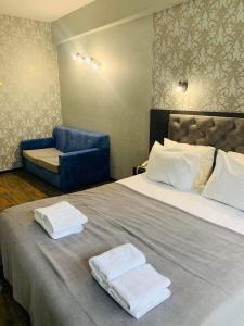 een slaapkamer met een groot bed en 2 handdoeken bij Villa ReTa Hotel & SPA in Grigoleti