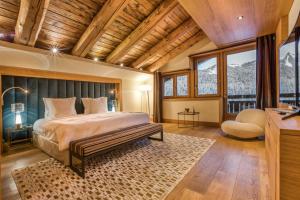 una camera da letto con un letto con soffitto in legno di Rock and Stars Megève a Megève Altre 14 foto