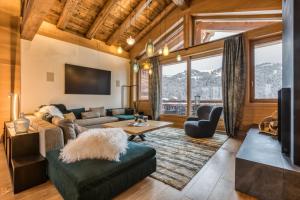un soggiorno con un divano e una TV di Rock and Stars Megève a Megève