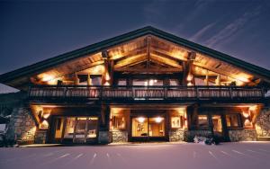 una baita di tronchi nella neve di notte di Rock and Stars Megève a Megève