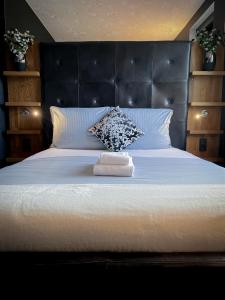 a bedroom with a large white bed with a black headboard at Boutique Hotel Schulz Classic in Neustadt am Rübenberge