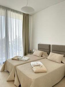 a bedroom with two beds with towels on them at Akamas Turtle Beach №2 in Neo Chorio