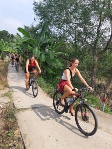 a group of people riding bikes down a path at Phuong Thao Homestay in Vĩnh Long