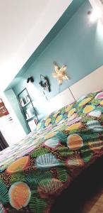 a bedroom with a bed with a colorful bedspread at Le Chalet de Pyrène et Hercule in Arignac