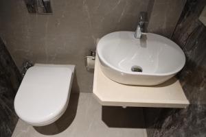 a bathroom with a white toilet and a sink at Vishal Hall in Mumbai
