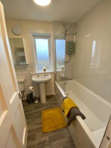 a bathroom with a dog standing in the bath tub at Traditional 3 bed town house in Inverlochy +24 photos