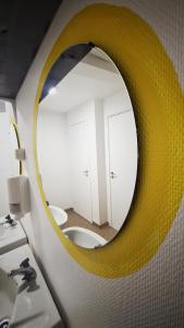 a bathroom with a yellow mirror over a sink at Orrefors Vandrarhem in Nybro