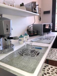 a kitchen counter with a coffee maker and glasses on it at TOBY HOUSE in Calasetta