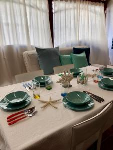 a table with green plates and a starfish on it at TOBY HOUSE in Calasetta