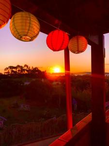 a sunset seen through a window with paper lanterns at TOBY HOUSE in Calasetta