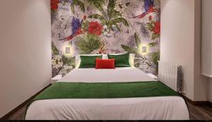 Abando Suites by Next Stop Bilbao في بلباو: غرفة نوم بسرير كبير ومخدات خضراء وحمراء