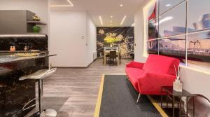 a living room with a red couch and a table at Abando Suites by Next Stop Bilbao in Bilbao +17 photos