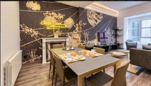 Abando Suites by Next Stop Bilbao في بلباو: غرفة طعام مع طاولة ومدفأة
