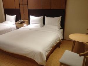珠海市にあるJi Hotel Zhuhai Gongbei Branchのホテルルーム内の大きな白いベッド