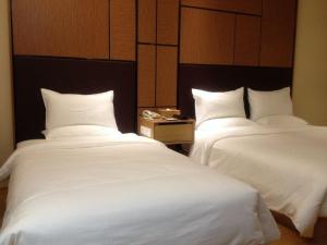 Łóżko lub łóżka w pokoju w obiekcie Ji Hotel Zhuhai Gongbei Branch