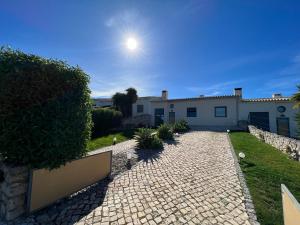 a house with a stone driveway in front of it at Casa Parreira Raposeira, Algarve in Raposeira
