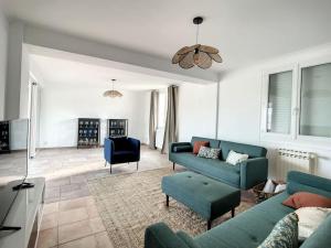 a living room with a blue couch and chairs at La VILLA Ismaila in Sainte-Feyre