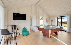 eine Tischtennisplatte in einem Zimmer mit einem TV in der Unterkunft Amazing Home In Hrve With Sauna in Hørve