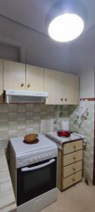 Il comprend une cuisine équipée d'une cuisinière et d'un four blanc. dans l'établissement Anchialos seafront appartement, à Nea Anchialos