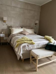 a bedroom with a large white bed and a bench at Studio Montaigne in Liège