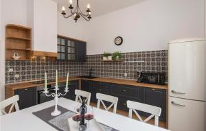 Il comprend une cuisine équipée d'une table et d'un réfrigérateur blanc. dans l'établissement Stunning Home In Orebic With 4 Bedrooms, Jacuzzi And Wifi, à Orebić