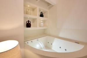una vasca da bagno bianca in una stanza con scaffali di Dimora San Giuseppe a Lecce