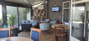 a living room with tables and chairs and a couch at Kyriad Tarbes Odos in Odos