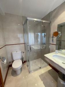 a bathroom with a shower and a toilet and a sink at Hotel Arturo in La Pobleta de Bellvei