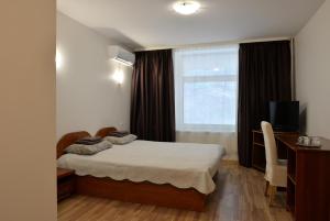 niewielka sypialnia z łóżkiem i oknem w obiekcie Baltosios Bures w Kownie