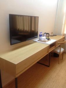 a wooden desk with a television on top of it at Ji Hotel Zhuhai Gongbei Branch in Zhuhai