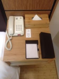 a desk with a phone and a tablet on it at Ji Hotel Zhuhai Gongbei Branch in Zhuhai