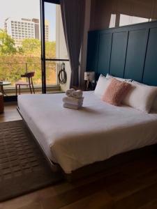 - une chambre avec un grand lit et des serviettes dans l'établissement 威尼斯民宿, à Tainan
