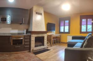 a kitchen with a living room with a fireplace at AlaiSuberri in Oronz