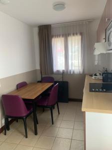 eine Küche mit einem Holztisch und lila Stühlen in der Unterkunft Appartement T2 Centre Valberg in Valberg