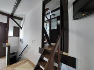 escalera en una habitación con paredes blancas y suelo de madera en Apartament Krawcownia en Świebodzin