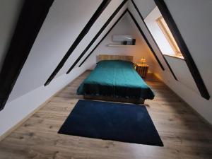 een zolderkamer met een bed en een raam bij Apartament Krawcownia in Świebodzin