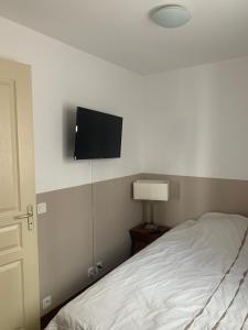 a bedroom with a bed and a flat screen tv on the wall at Appartement T2 Centre Valberg in Valberg