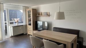 ein Wohnzimmer mit einem Esstisch und einem TV in der Unterkunft Apartment Yoursylt One in Westerland