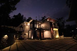 a house at night with its lights on at DIGA VISTA LAKE VIEW COTTAGE in Munnar