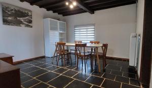 a kitchen with a table and chairs and a refrigerator at La Rustique in Dinant