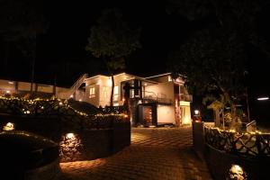 a house at night with lights in front of it at DIGA VISTA LAKE VIEW COTTAGE in Munnar