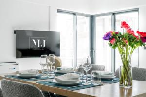 a dining room table with plates and glasses and flowers at Maison Du Jardin 2-Bedroom Apartment Private Outdoor Jacuzzi in Rhodes Town