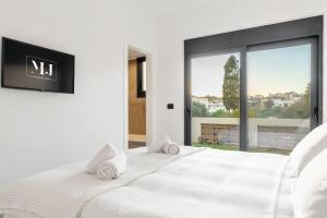 een slaapkamer met een groot wit bed en een groot raam bij Maison Du Jardin 2-Bedroom Apartment Private Outdoor Jacuzzi in Rhodos-stad