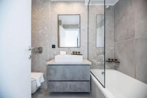 een badkamer met een wastafel, een bad en een toilet bij Maison Du Jardin 2-Bedroom Apartment Private Outdoor Jacuzzi in Rhodos-stad +35 foto's