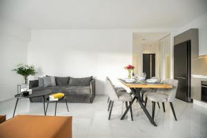 ロードス・タウンにあるMaison Du Jardin 2-Bedroom Apartment Private Outdoor Jacuzziのリビングルーム(ソファ、テーブル、椅子付)