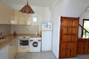 a kitchen with a white refrigerator and a washing machine at Bodrum Gundogan Full Sea View With Garden Triplex Villa in Bodrum City