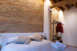 a bedroom with a brick wall and a bed with pillows at Niu del Sol in Vic