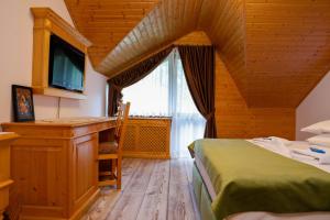 1 dormitorio con 2 camas, escritorio y ventana en Casa Baciu, en Fundu Moldovei